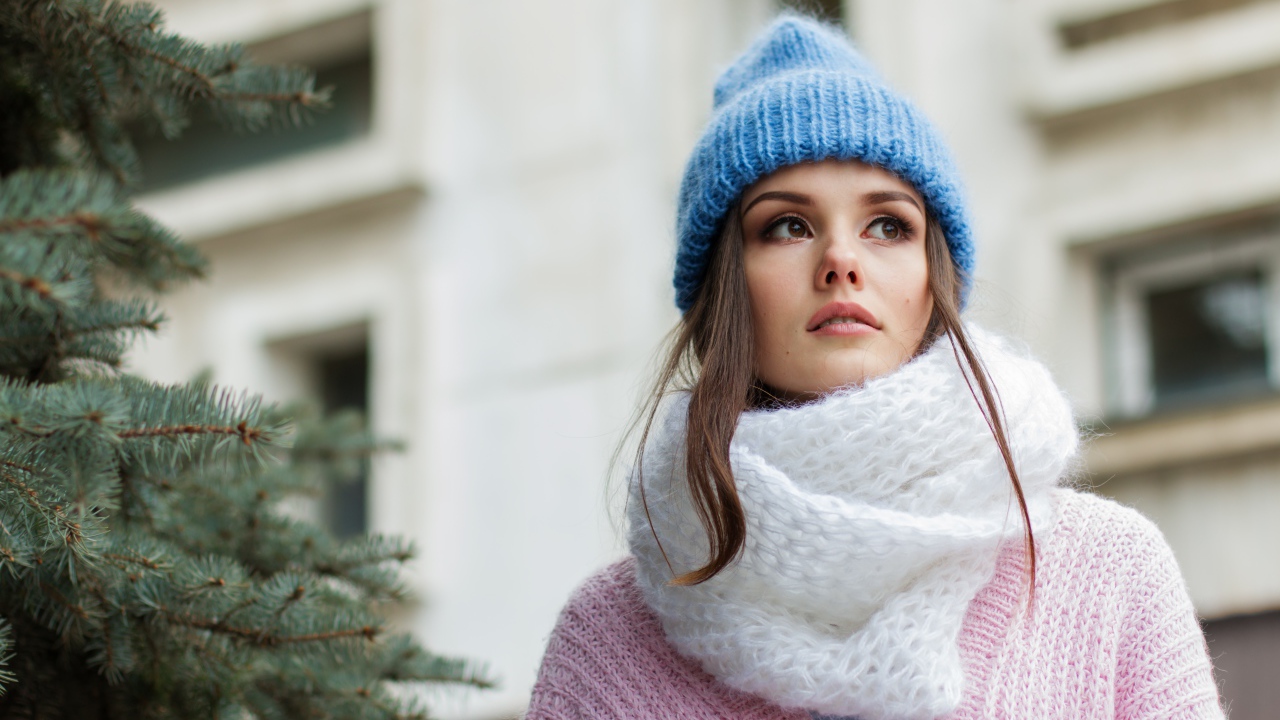 Girl in a warm blue hat with a white scarf
