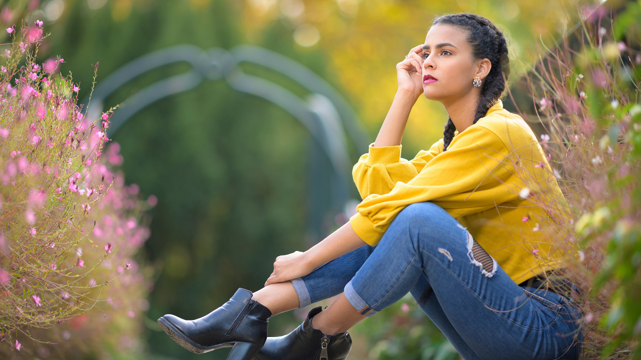 Девушка в джинсах сидит на земле 