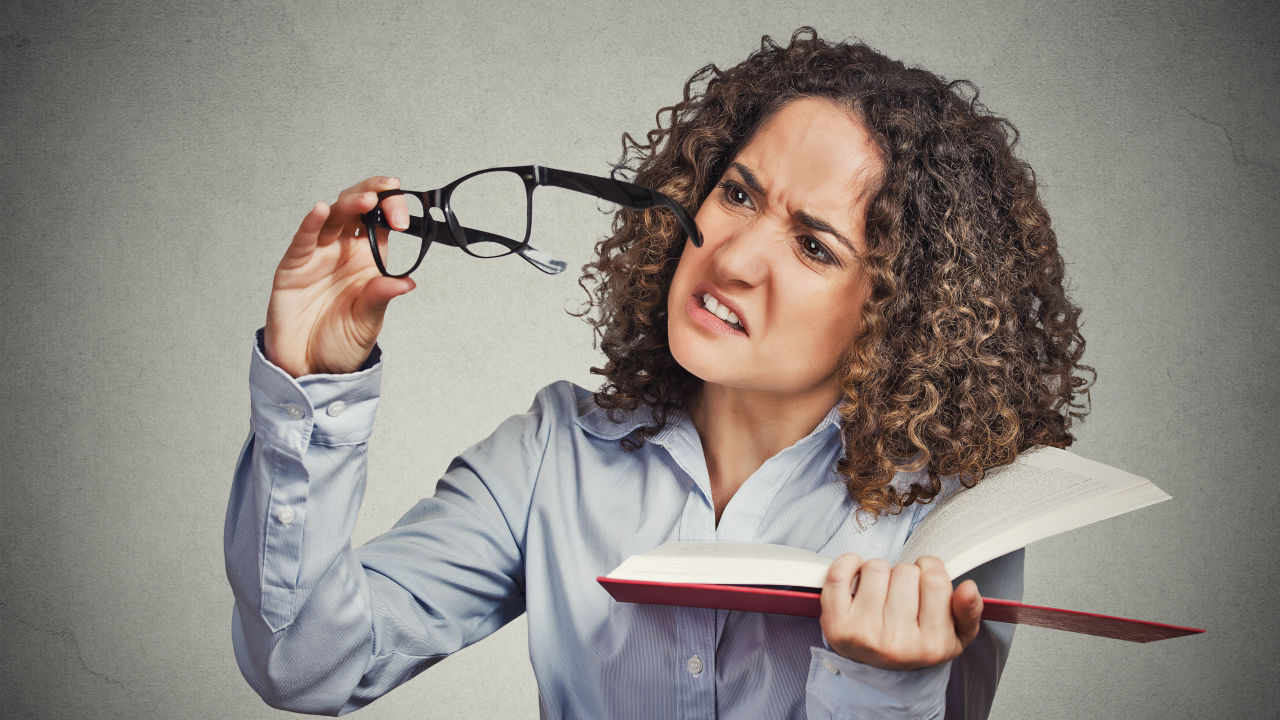 Девушка с книгой с очками в руке