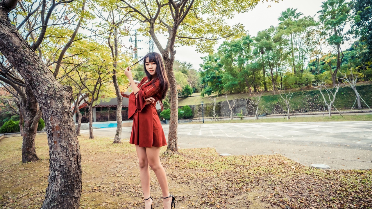 Длинноногая девушка азиатка в коротком красном платье 