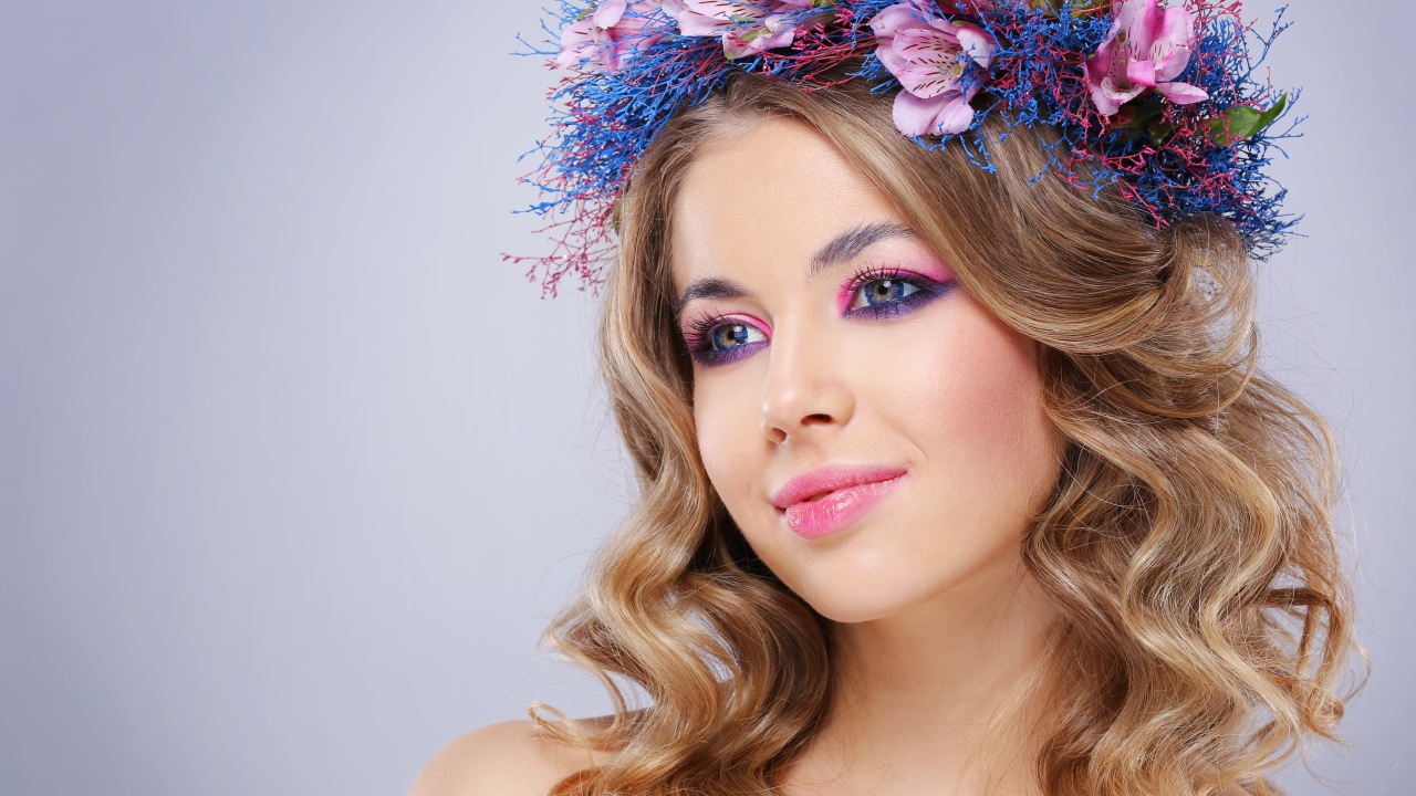 Милая девушка с венком на голове на сером фоне 