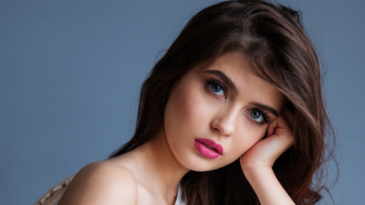 Милая девушка с розовыми губами на сером фоне