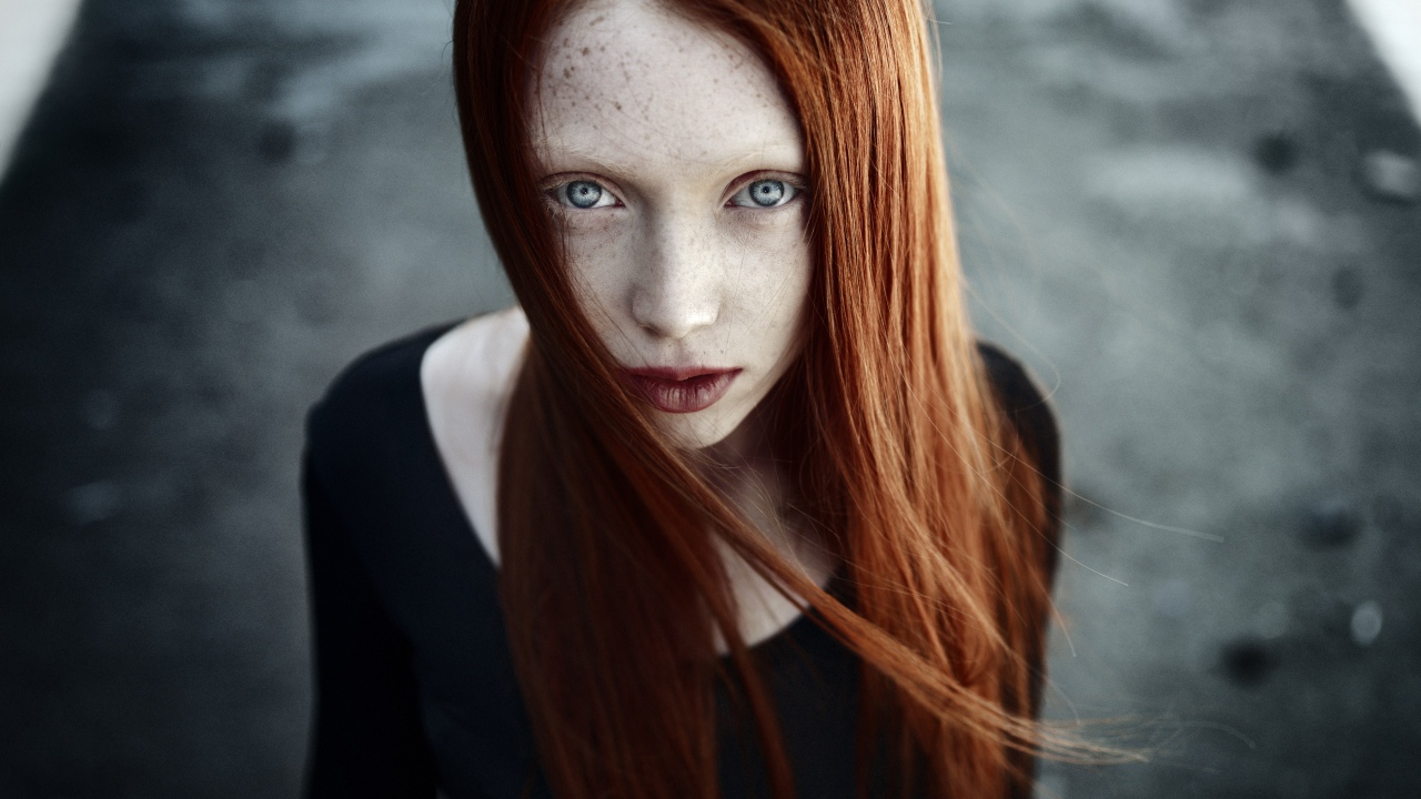 Рыжая длинноволосая девушка с веснушками на лице