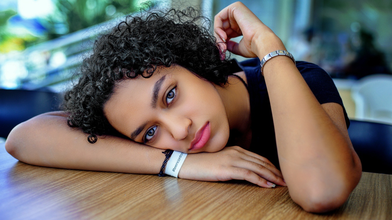 Грустная девушка за столом в кафе