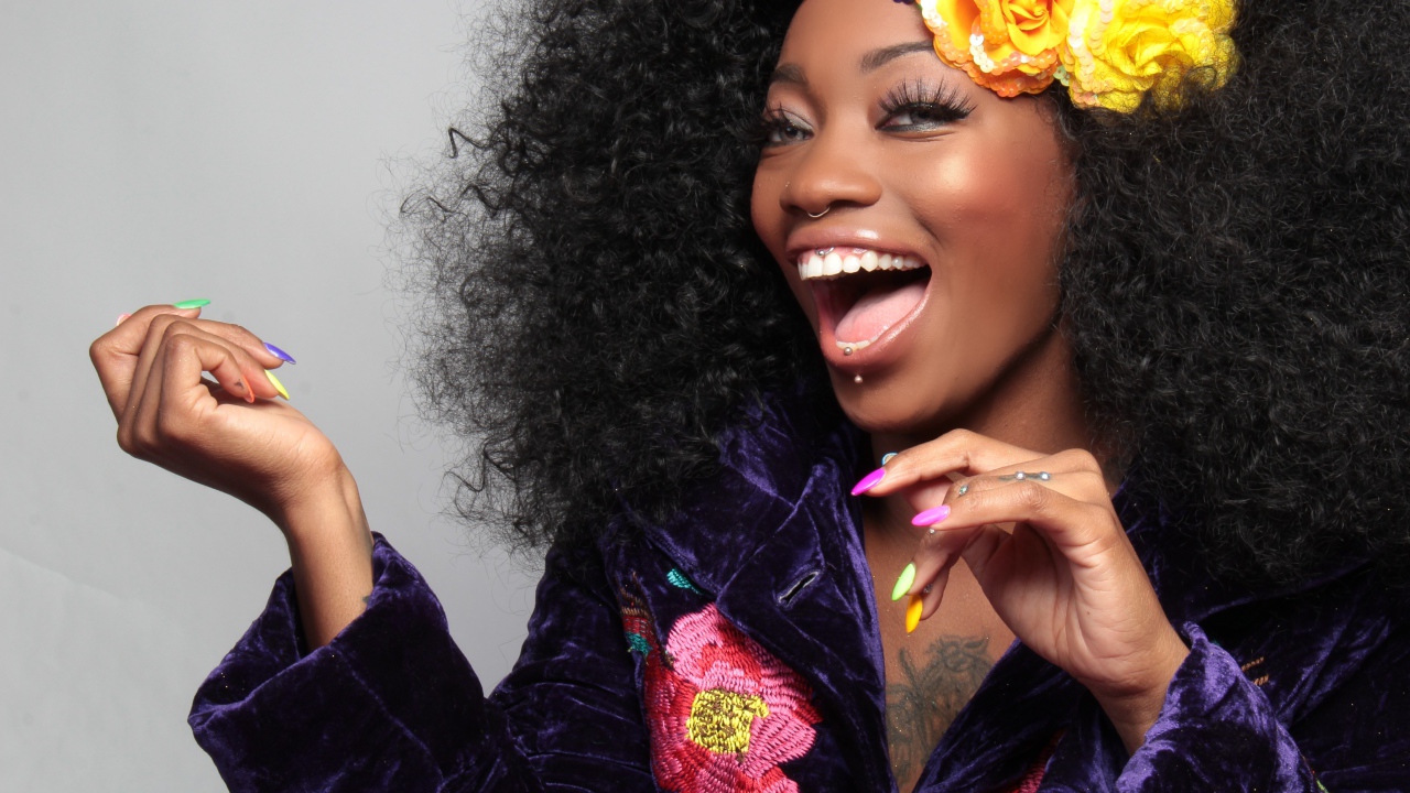 Улыбающаяся темнокожая девушка с цветами в волосах 