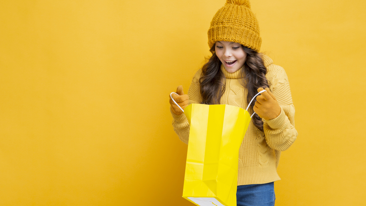 Улыбающаяся девушка в теплом свитере  с пакетом в руках 