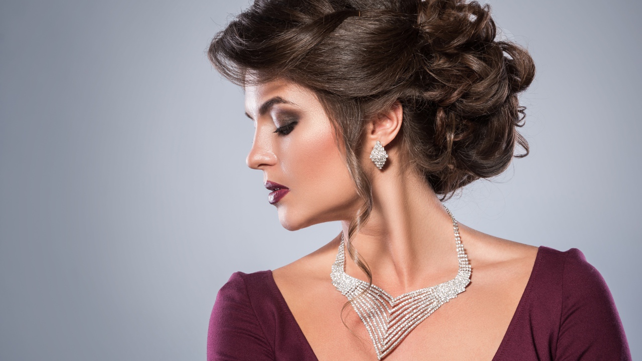 Стильная женщина с вечерней прической, макияжем и дорогими украшениями