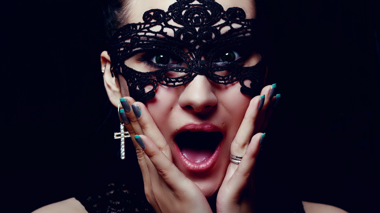 Удивленная девушка в черной маске на лице