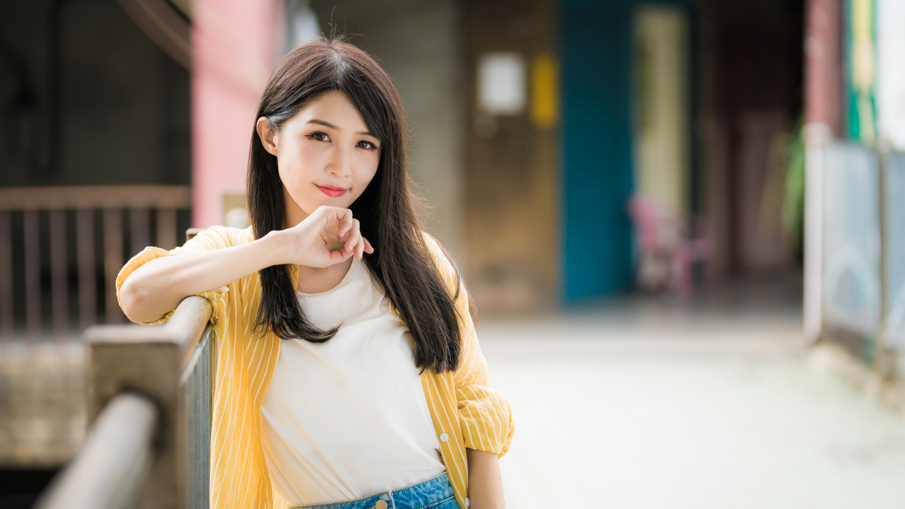 Молодая азиатка в белой майке и полосатой рубашке 