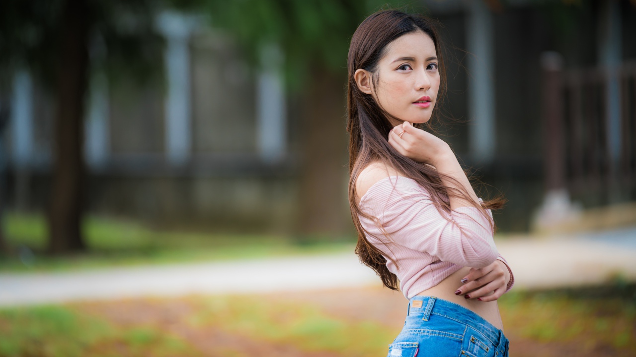 Молодая азиатка с длинными волосами в синих джинсах