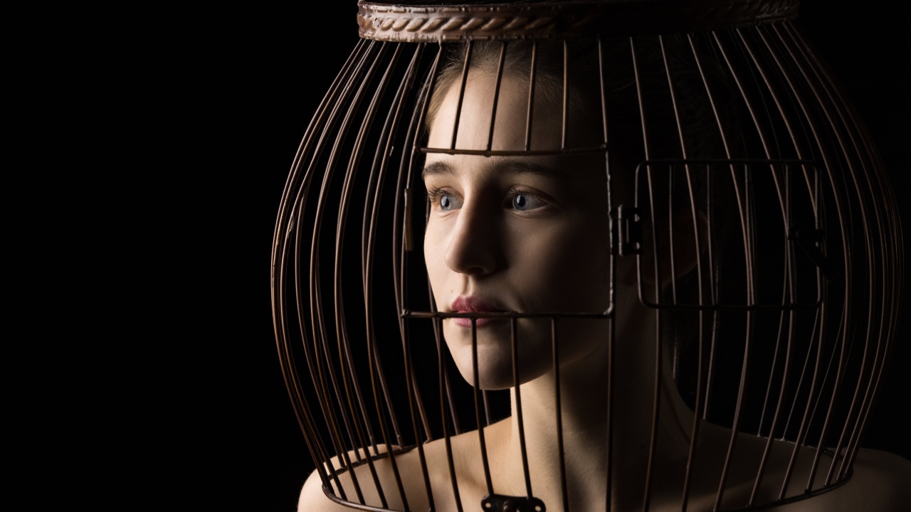 Молодая девушка с клеткой на голове 