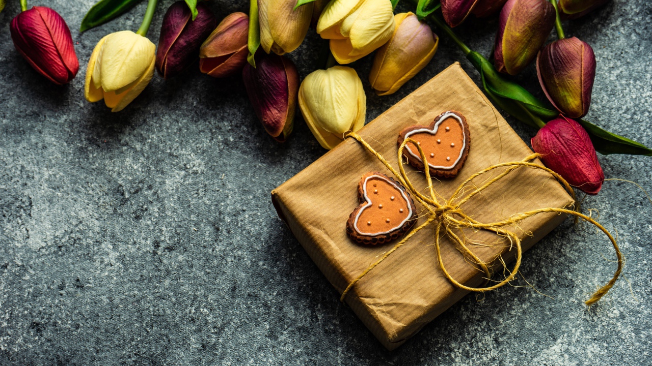 Подарок с букетом тюльпанов на сером столе