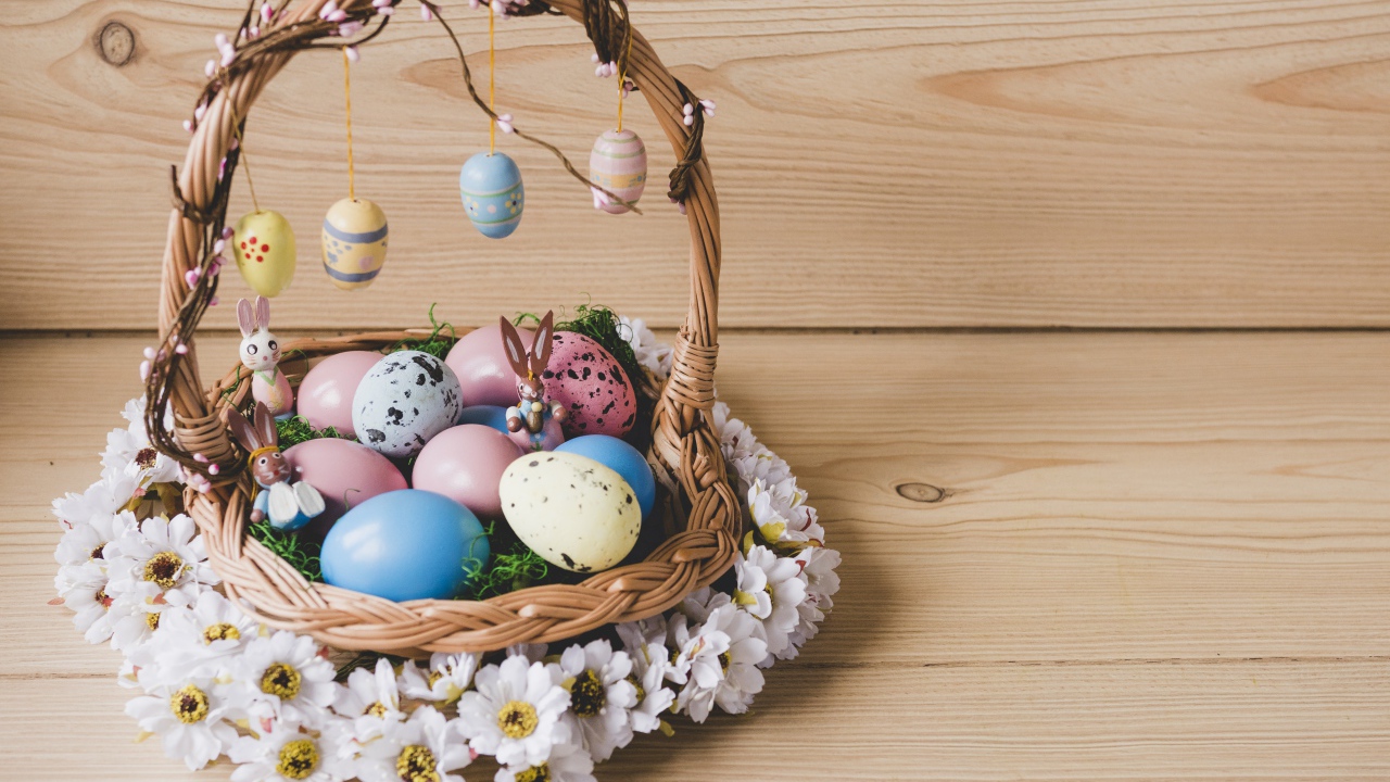 Корзинка с пасхальными яйцами украшена цветами