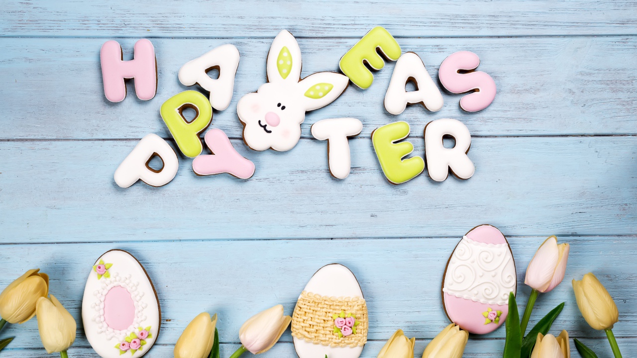 Красивое пасхальное печенье на столе с тюльпанами 