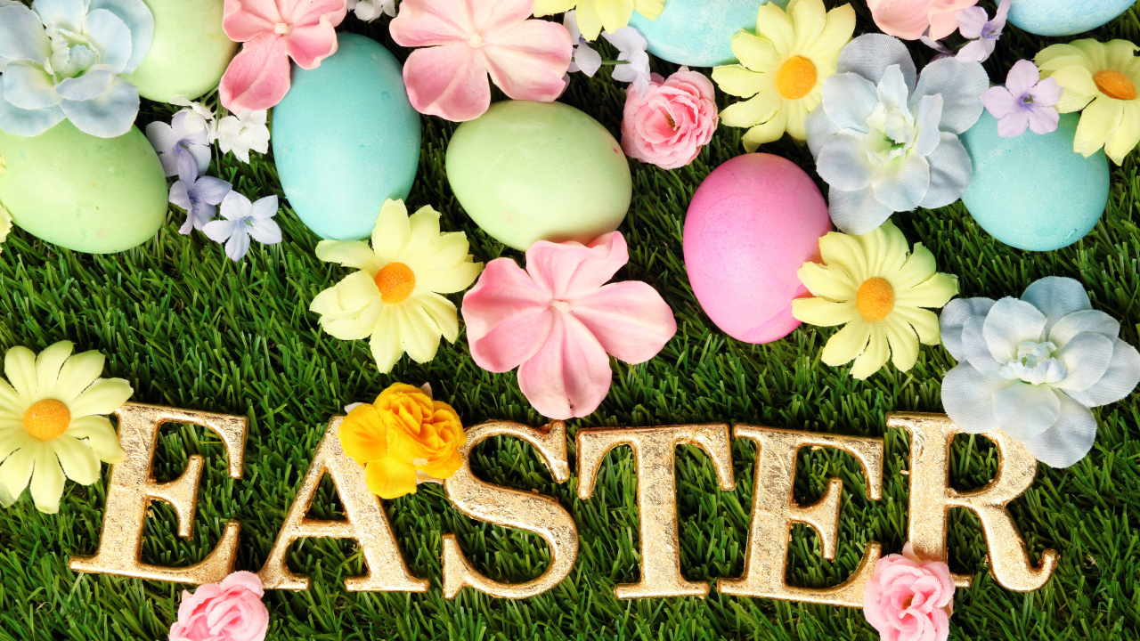 Надпись на траве с разноцветными яйцами и цветами на Пасху