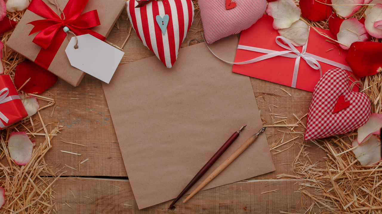 Сердечки из ткани на столе с бумагой и подарками 