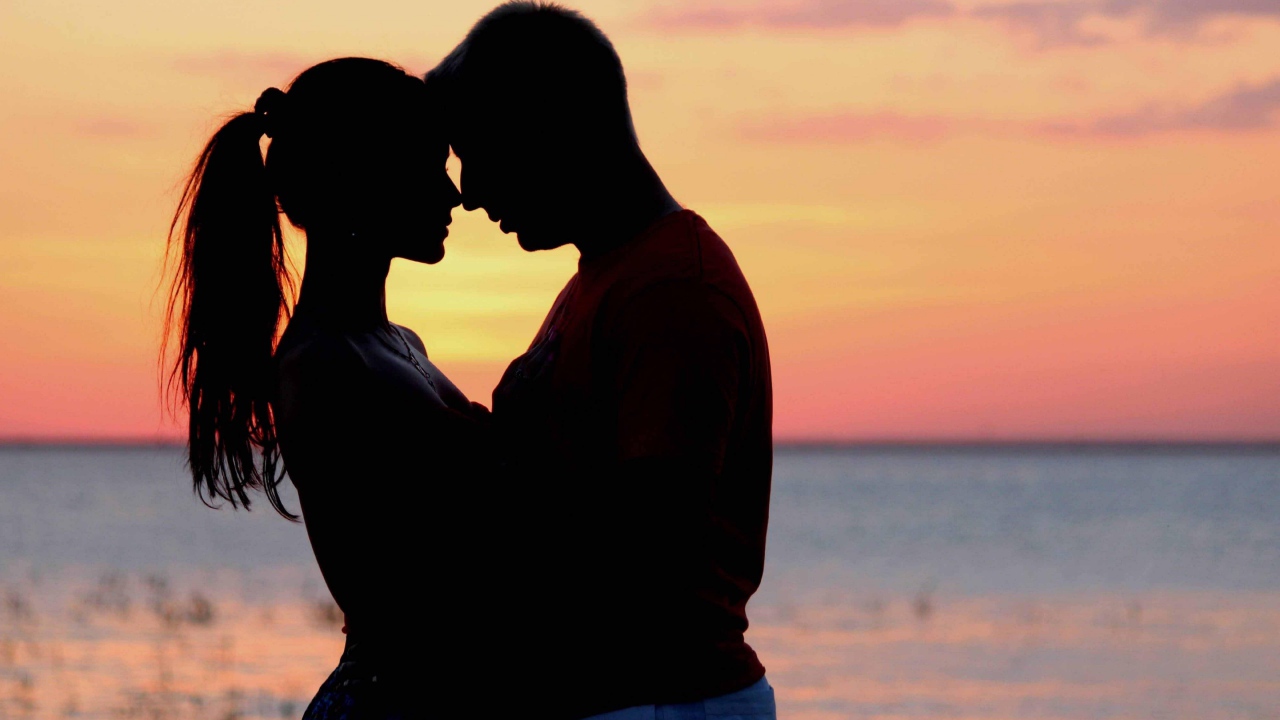 Влюбленная пара на фоне моря в сумерках 