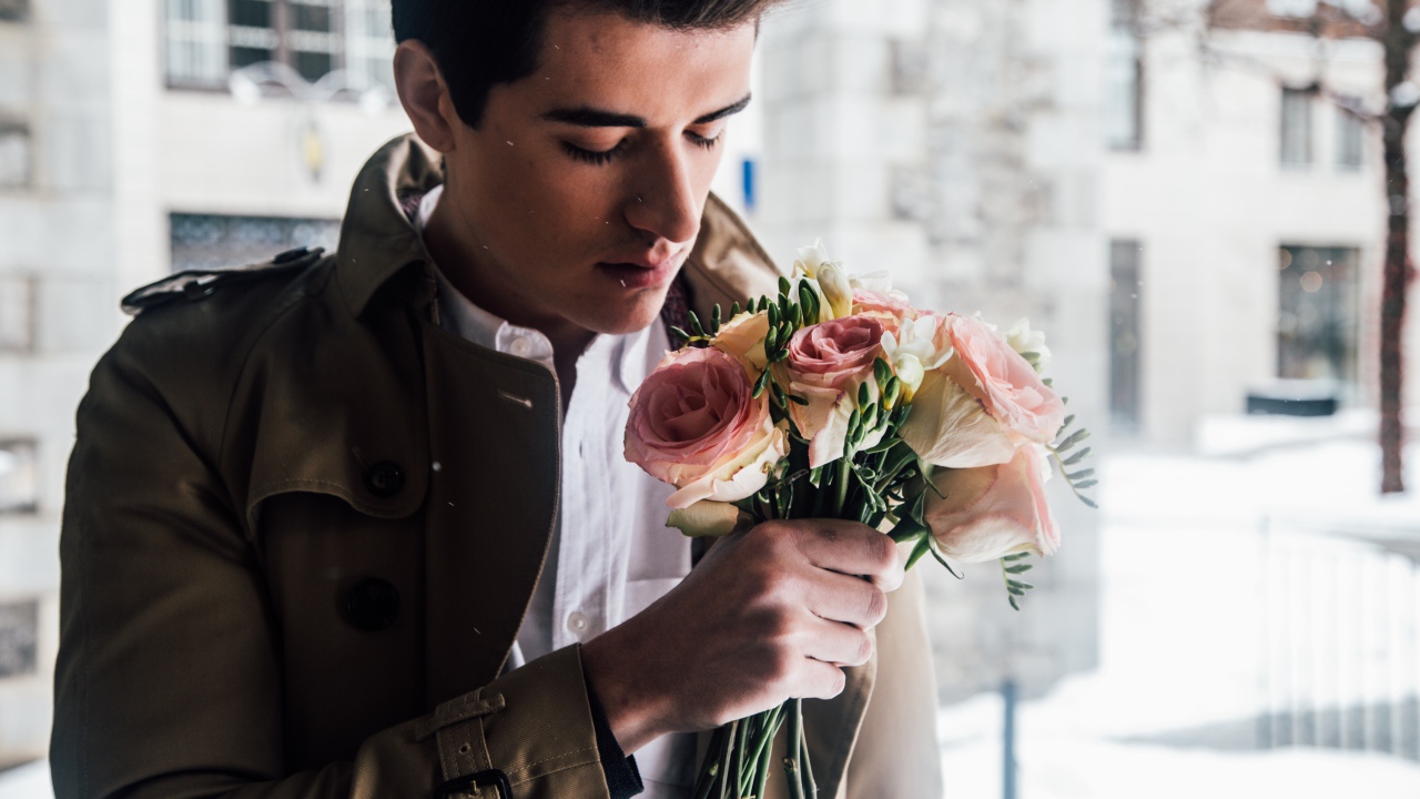 Красивый мужчина с букетом роз в руке