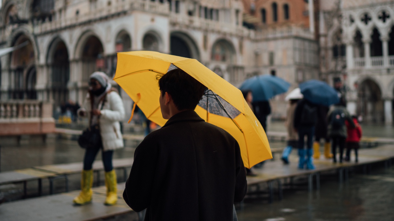 Мужчина с желтым зонтом в городе 