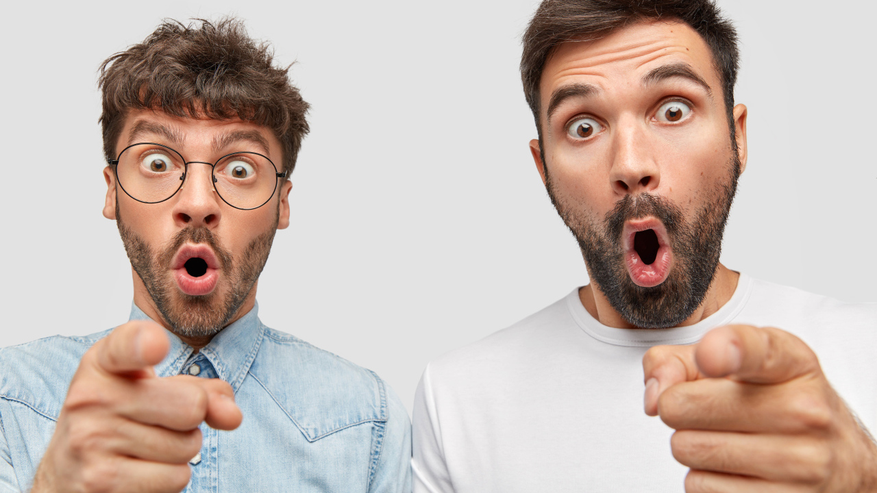 Два удивленных мужчины на сером фоне