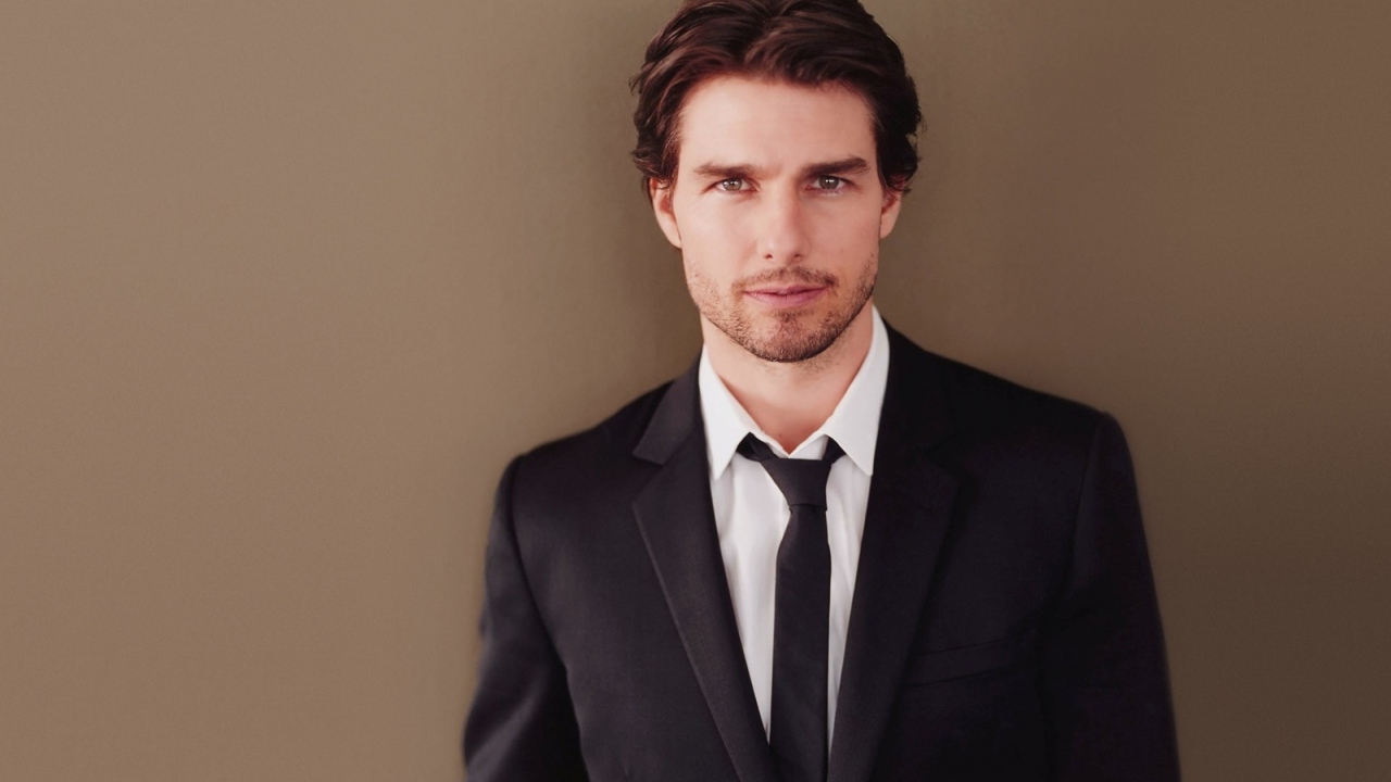 Популярный актер Том Круз в костюме на коричневом фоне