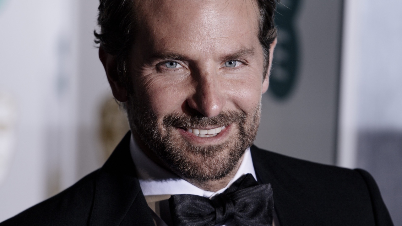 Улыбающийся актер Брэдли Купер в костюме