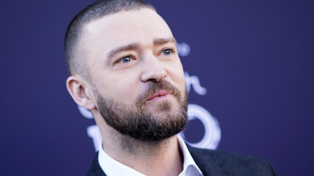 Лицо голубоглазого актера Джастина Тимберлейка на синем фоне