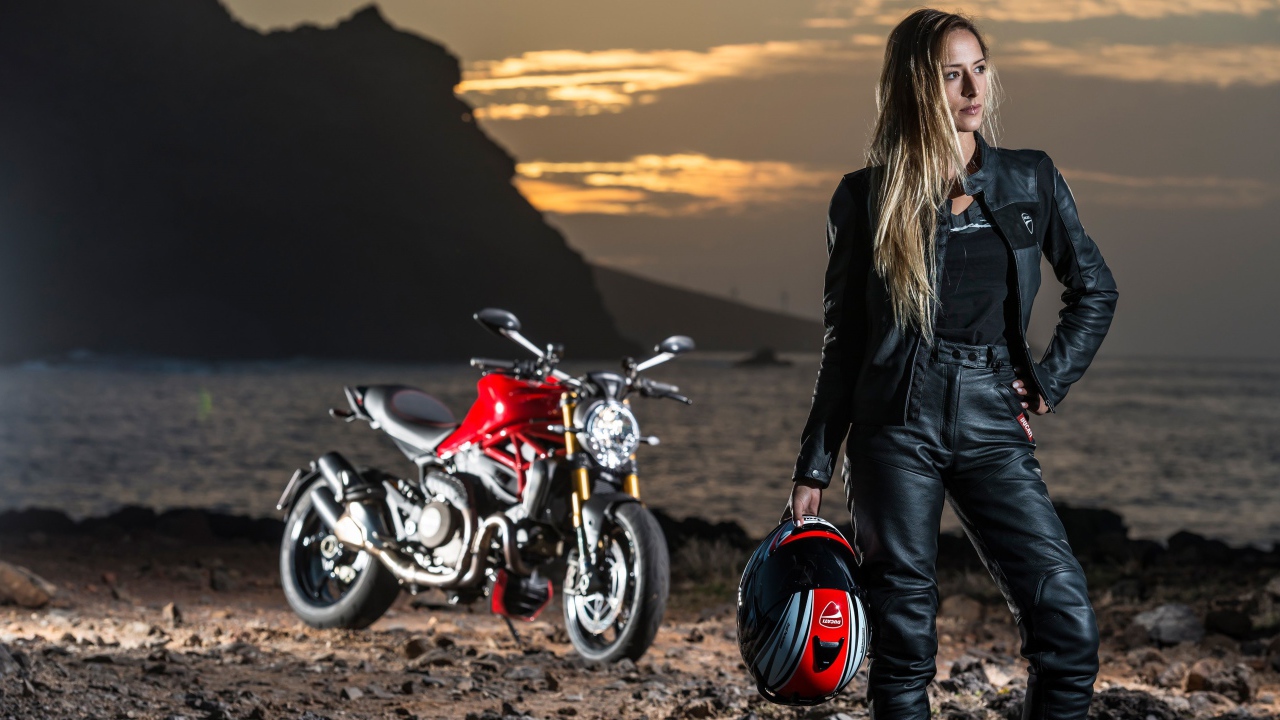 Молодая блондинка в кожаном костюме на мотоцикле