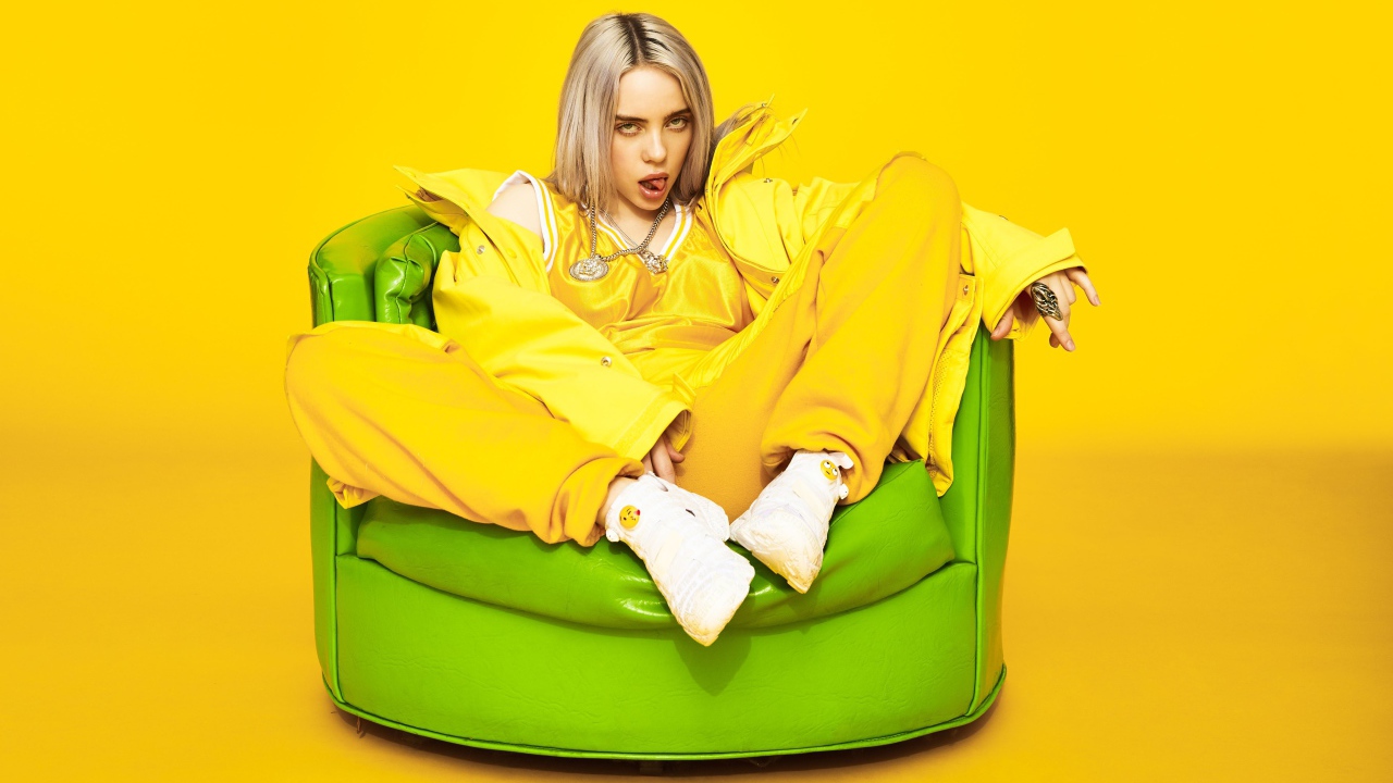 Американская певица Билли Айлиш в кресле на желтом фоне
