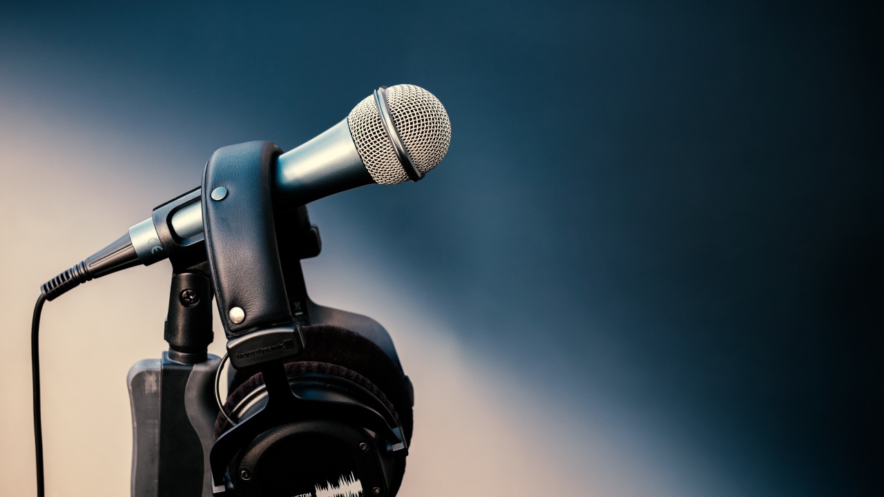 Микрофон с черными наушниками на стойке 