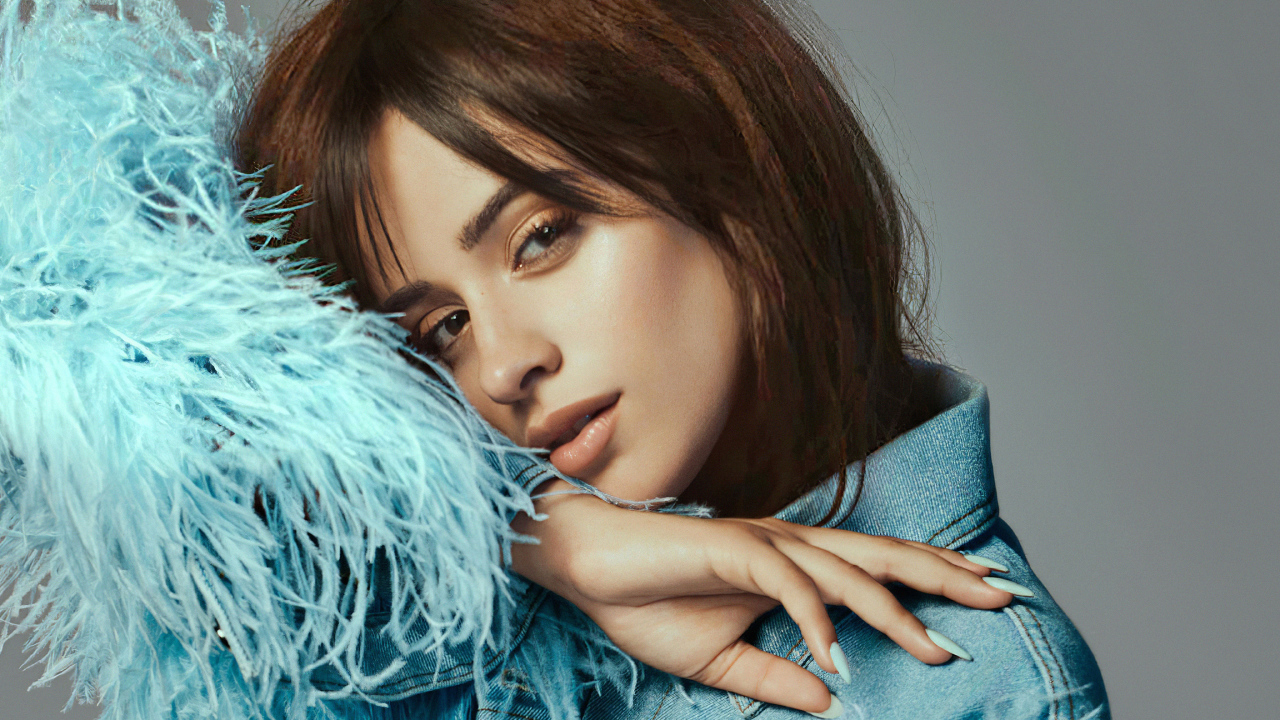 Певица Камила Кабельо в джинсовой куртке на сером фоне