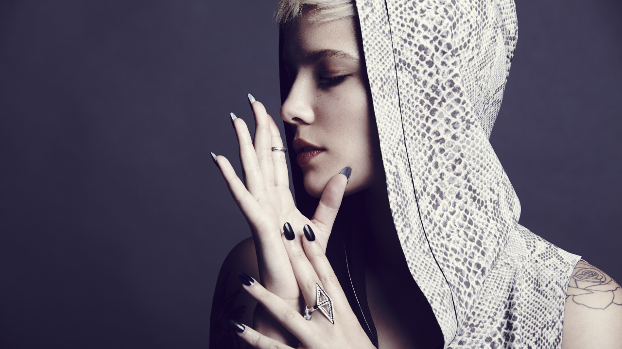 Певица Холзи в капюшоне на сером фоне