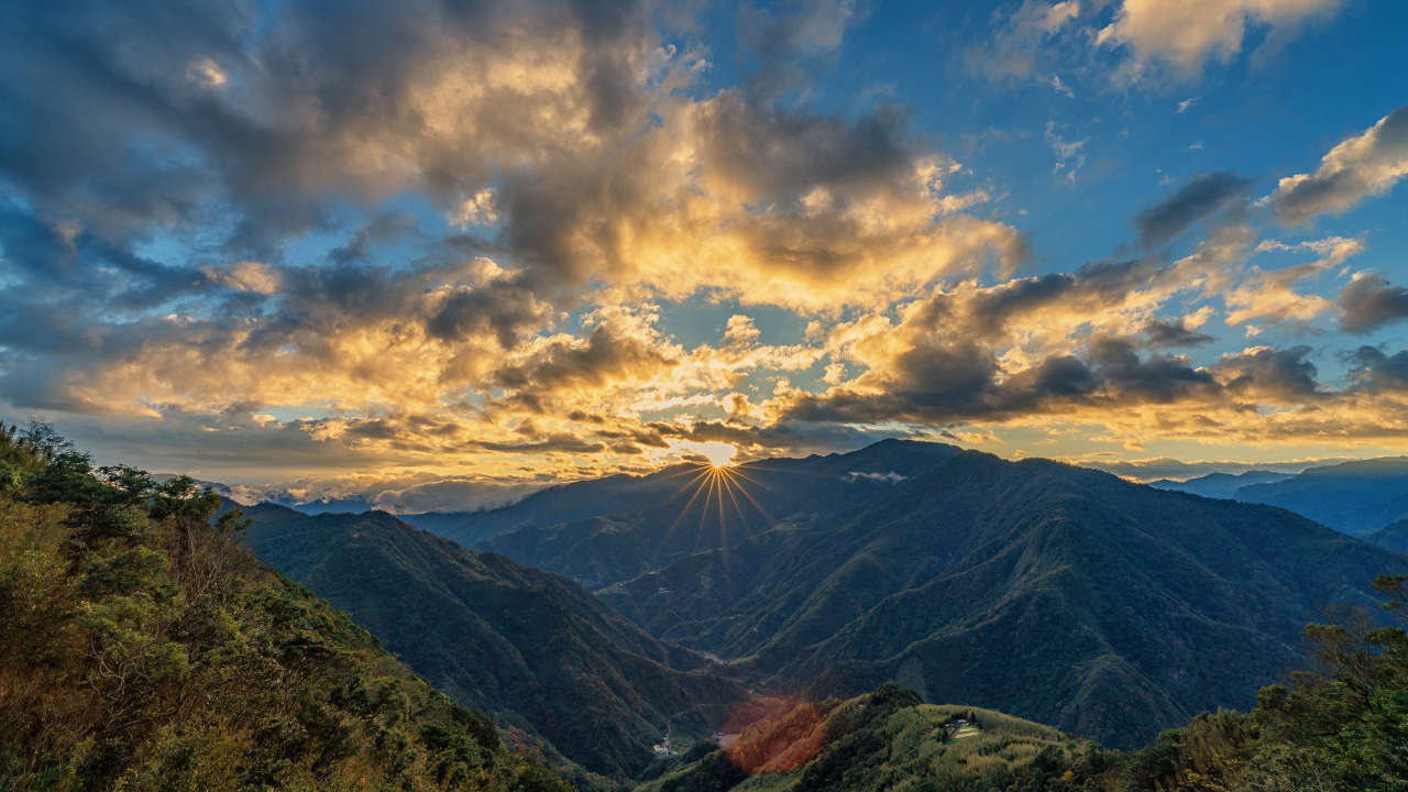 Рассвет солнца в облачном небе над горами 