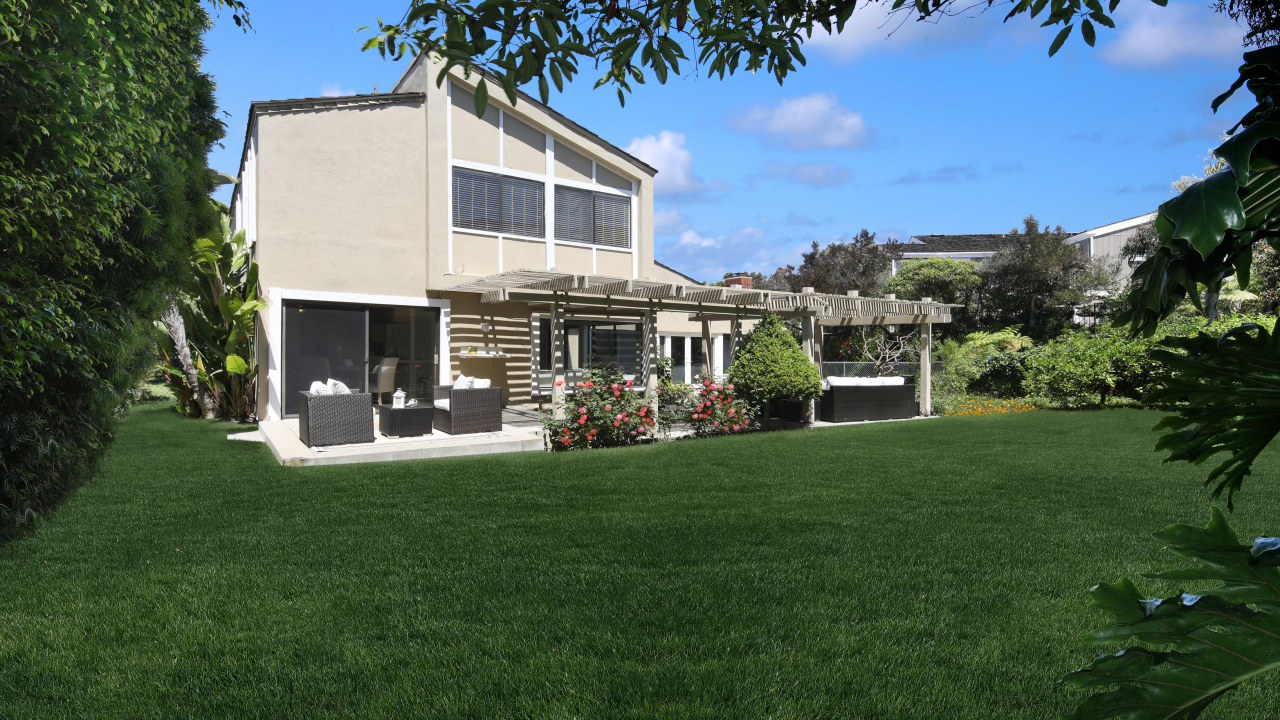 Двухэтажный дом с зеленым газоном 