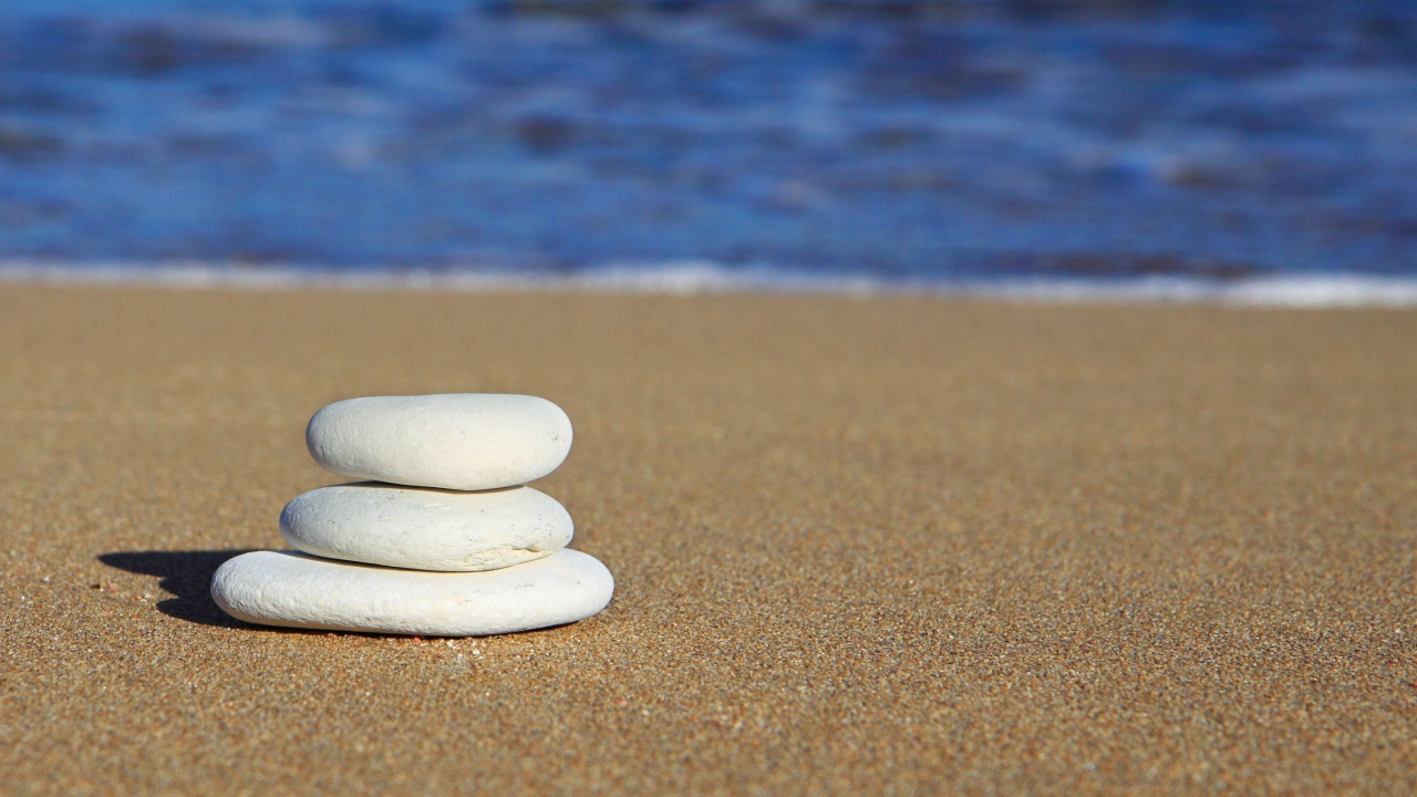 Круглые белые камни на желтом песке 