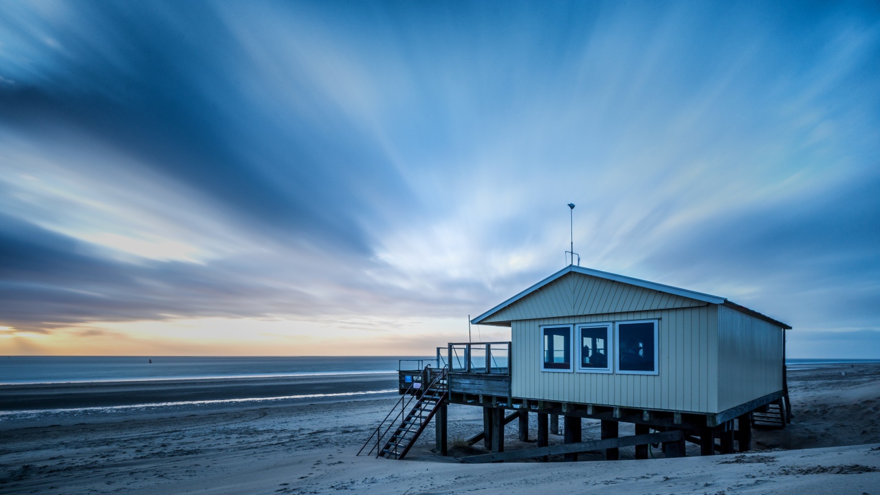 Дом спасателей стоит на пляже под красивым небом