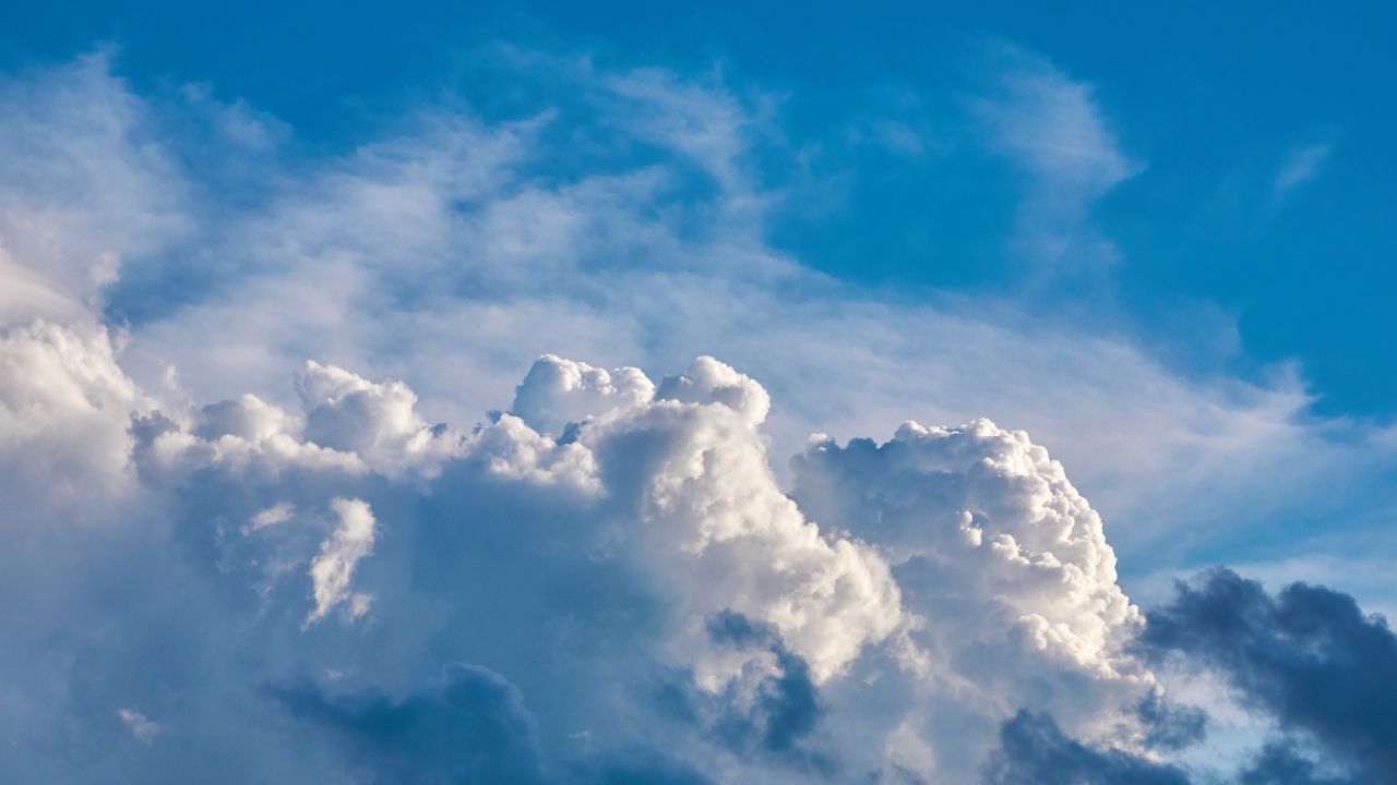 Густые белые облака в голубом небе  в лучах солнца