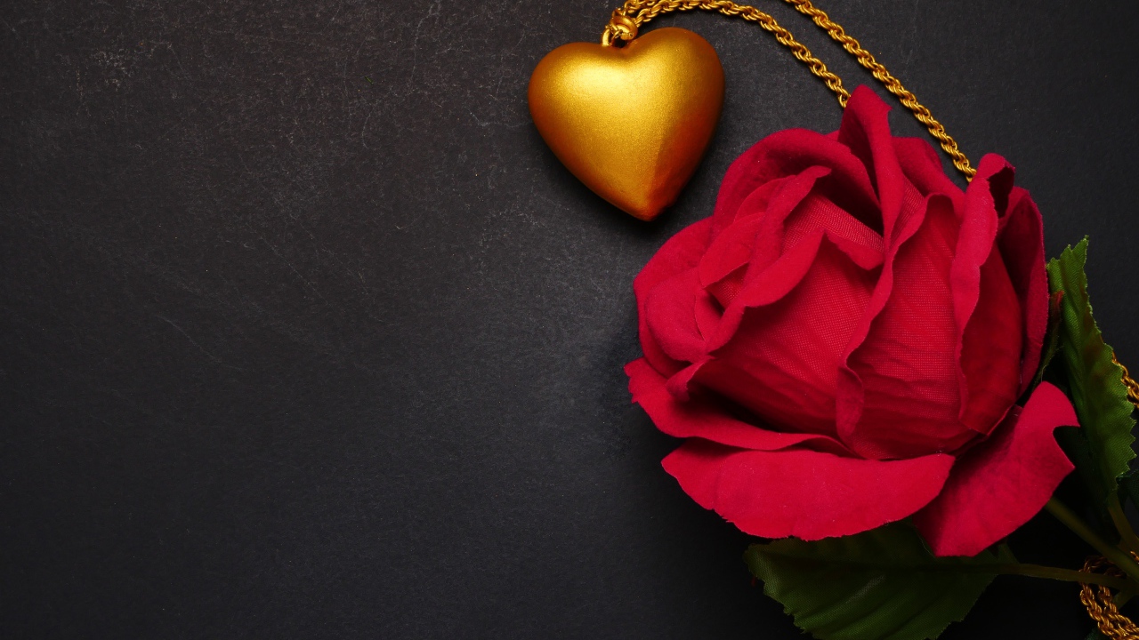 Искусственная красная роза с кулоном на сером фоне