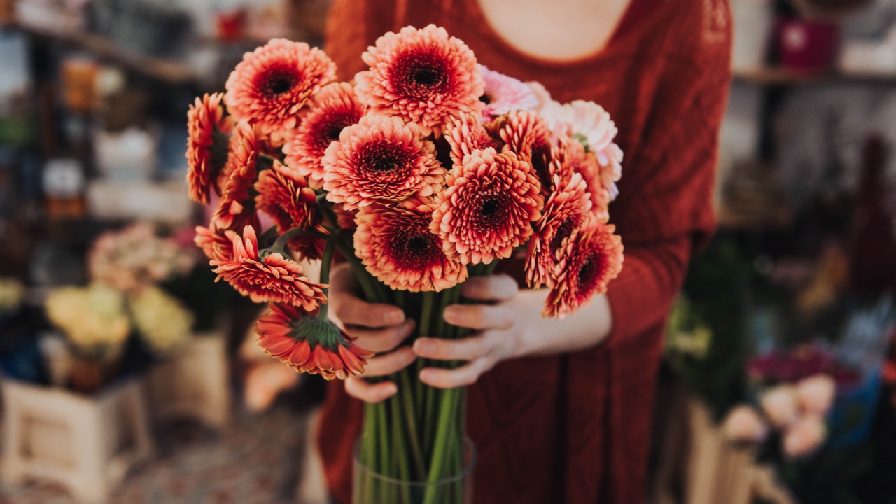 Красивый букет оранжевых гербер в руках у женщины 