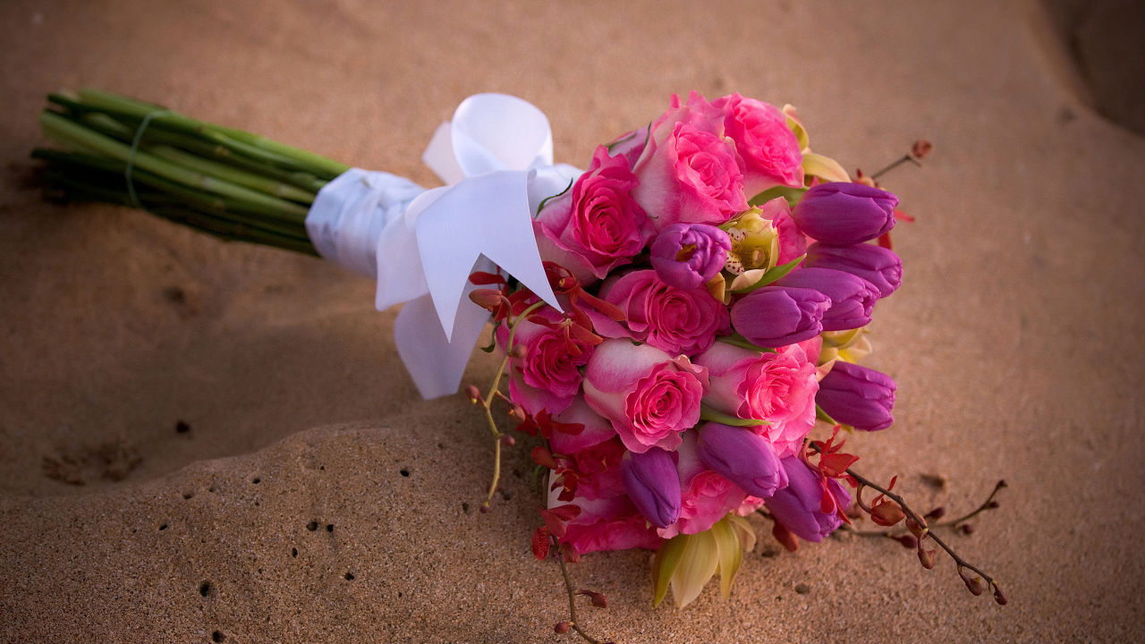 Красивый букет роз с тюльпанами лежит на песке