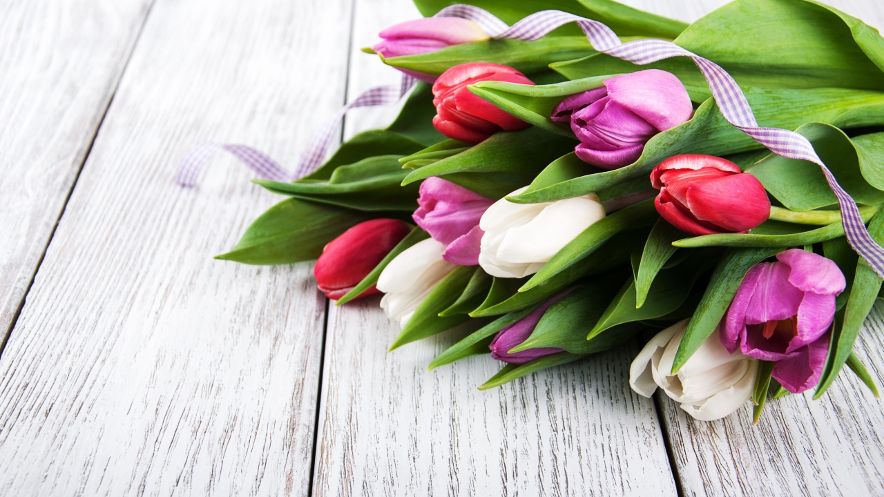 Букет свежих разноцветных тюльпанов на деревянном столе