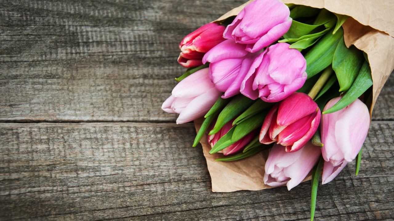 Букет розовых тюльпанов на деревянном столе 