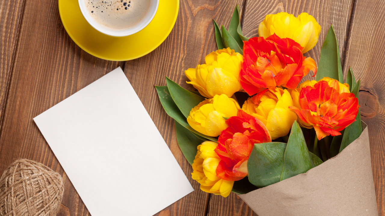 Букет тюльпанов на столе с листом бумаги и чашкой кофе