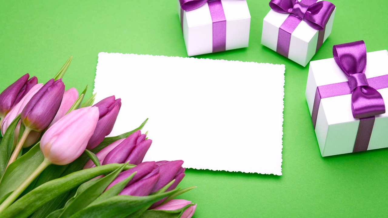 Букет тюльпанов на столе с листом бумаги и подарками 