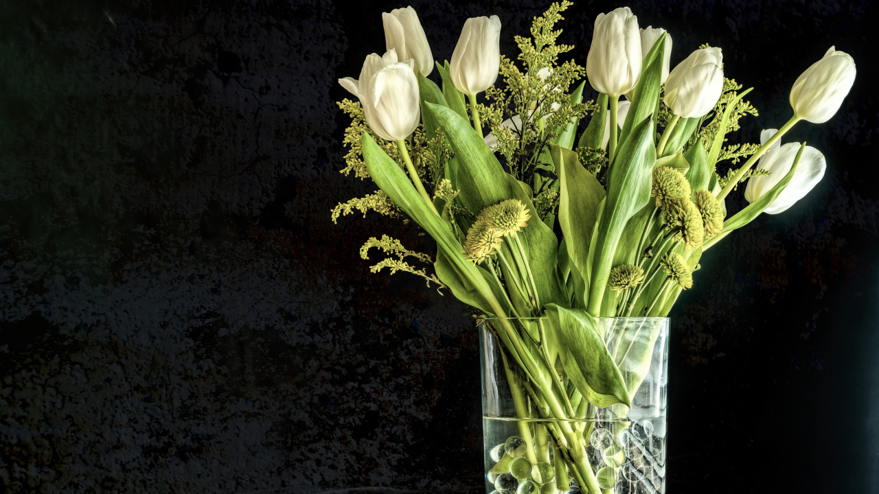 Букет белых тюльпанов с зелеными хризантемами в вазе на черном фоне 