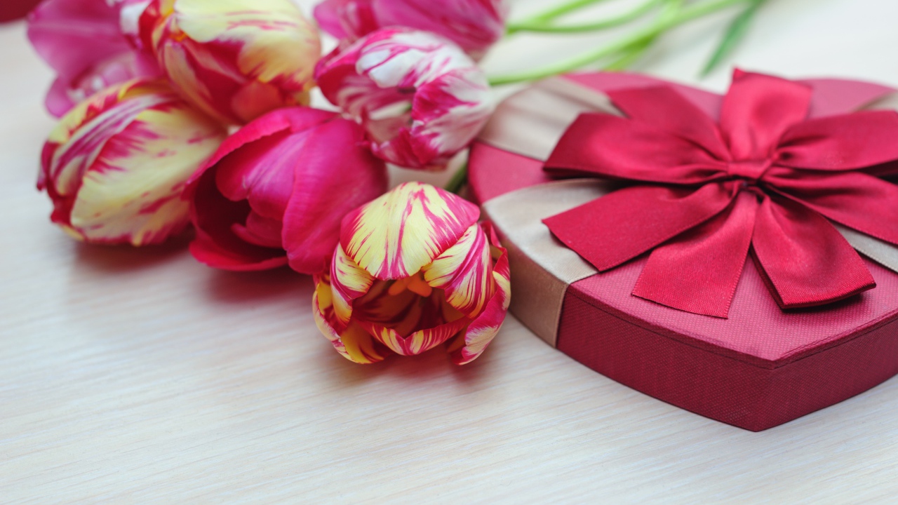 Коробка в форме сердца на столе с букетом тюльпанов