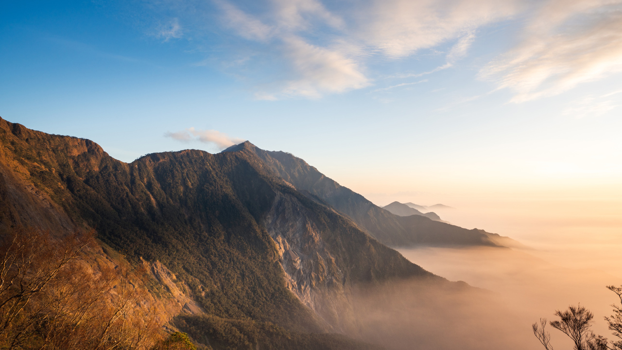 Красивый вид на покрытые туманом горы под голубым небом
