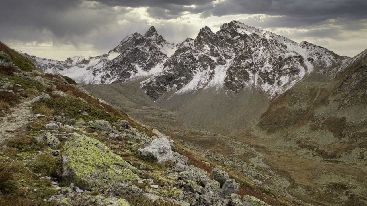 Высохшая река в горах под грозовым небом