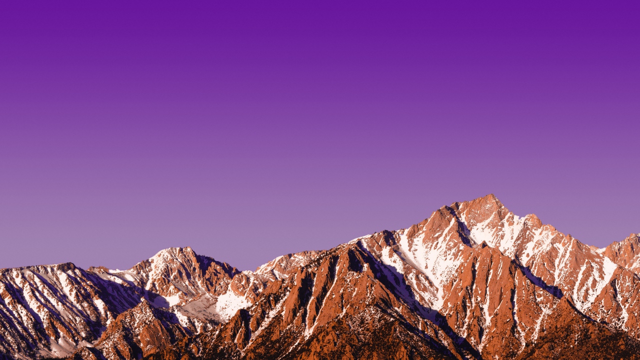 Вершины заснеженных гор на фоне сиреневого заката