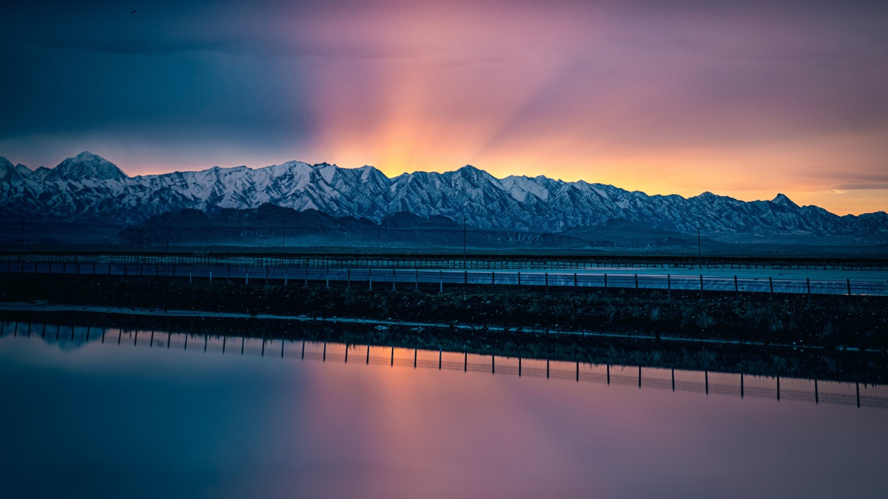 Заснеженные горы на рассвете у воды 